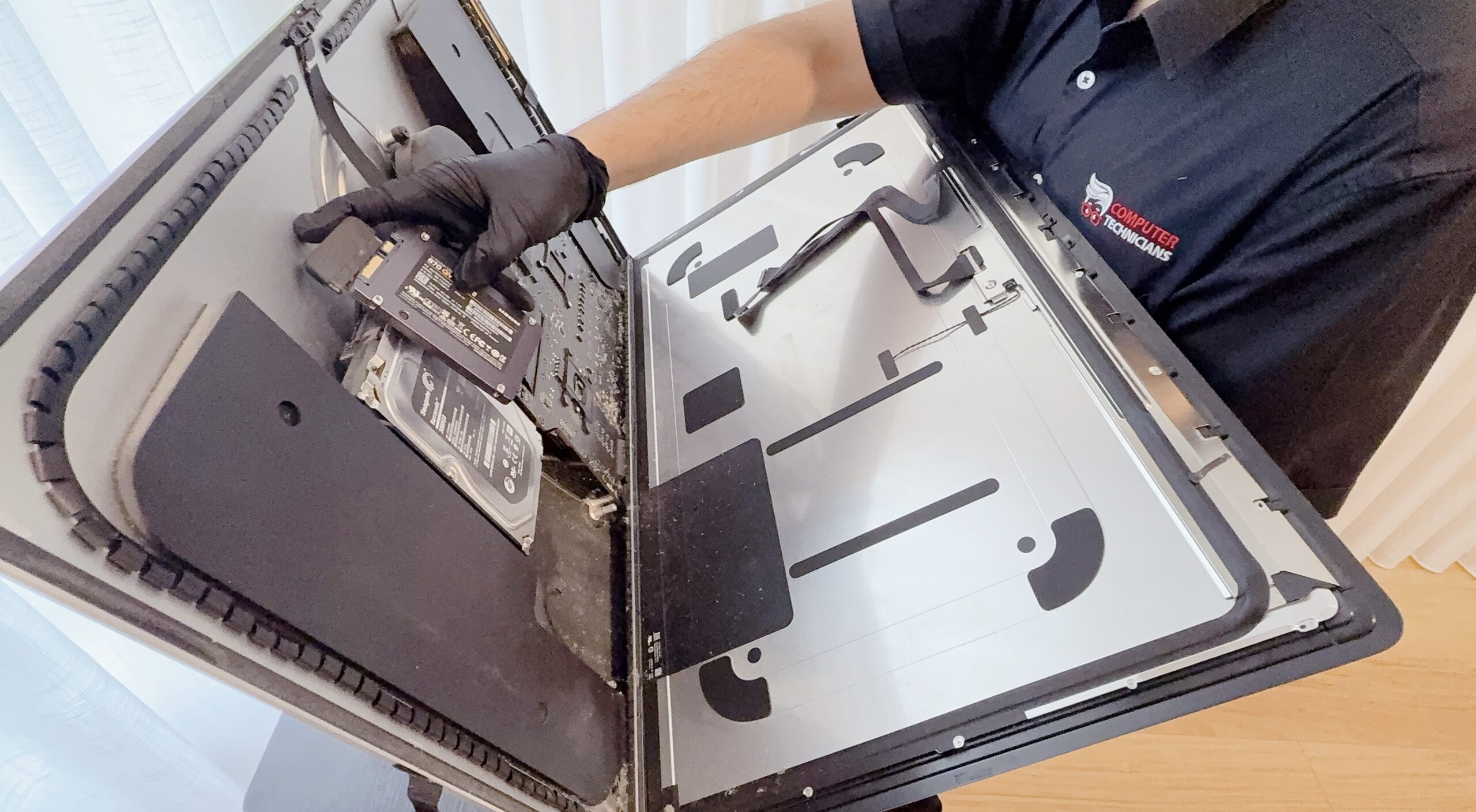 mac technician replacing HDD inside mac with an SSD