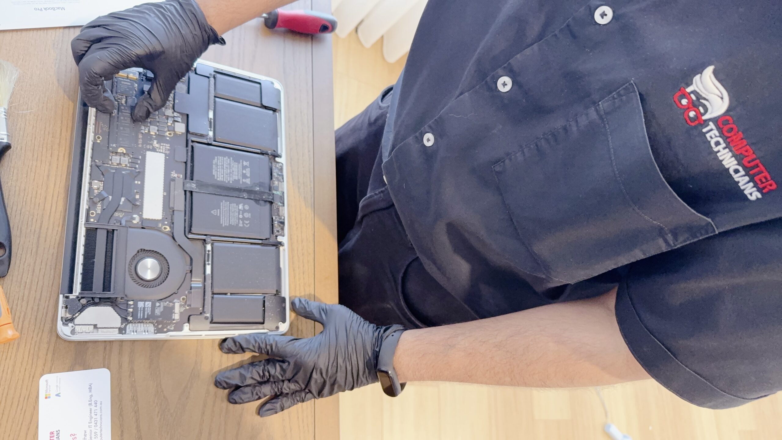 technician replacing the SSD in a MacBook